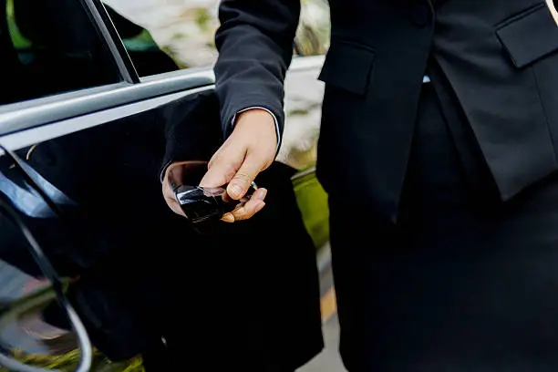 Chauffeur open door of luxury car for passenger in Carmel, new york